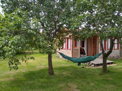 Ferienhütte auf der Wiese mit einigen schattenspendenden Bäumen