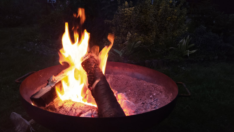 Feuerschale und gehacktes Holz vorhanden für Lagerfeuer
